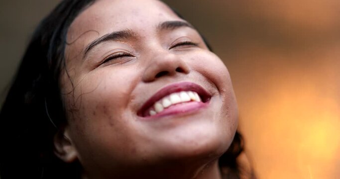 Joyful smiling hispanic woman face in the rain