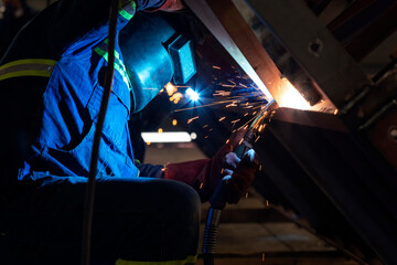 Fototapeta na wymiar Gas metal arc welding. It is a welding process which joins metals by heating the metals to their melting point with an electric arc and arc is struck between a continuous, consumable electrode wire.