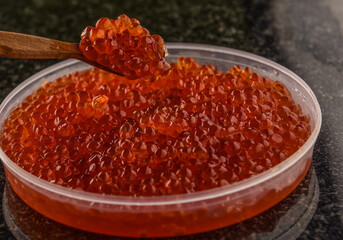 texture of red caviar, wooden spoon in red caviar