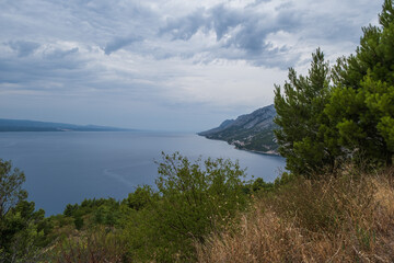 Fototapeta na wymiar Looking down to the coastline in town of Brela on the Adriatic coastline of Croatia. Cloudy august day, 2020