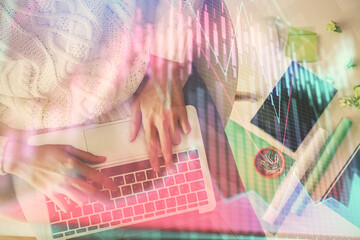 Multi exposure of woman hands working on computer and forex chart hologram drawing. Top View. Financial analysis concept.