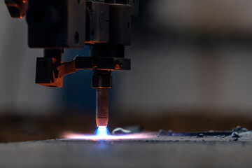 Cnc plasma cutting machine is cutting to steel plate in the factory. A Cnc plasma machine also...