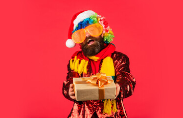 take this one. winter holiday party. mature guy celebrate new year. man with beard in santa claus hat. christmas online shopping. bearded hipster in xmas party glasses. brutal man hold present box