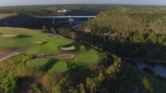 Players on Dye Fore golf course and view of surrounding landscape. Aerial