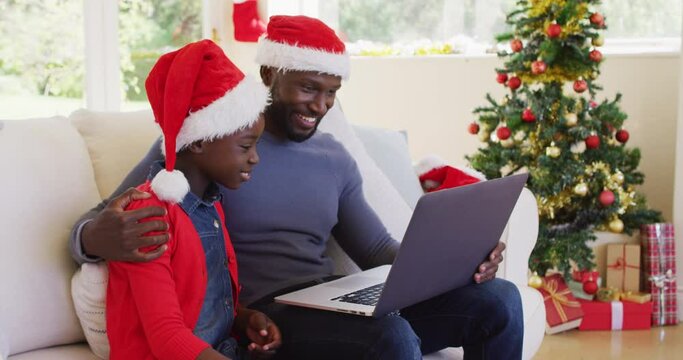 African american father and son having a videocall on laptop