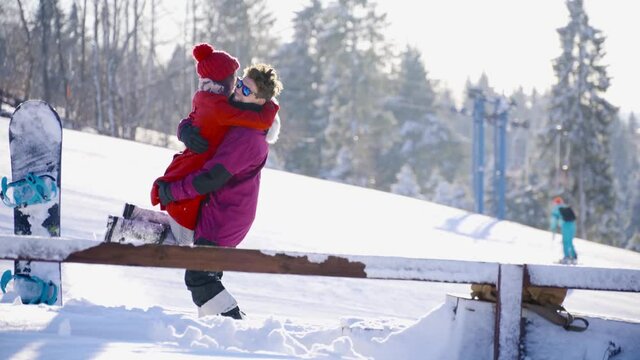 Multicultural coulple dating in mountain ski resort at sunny day. Winter, sport, holidays, relationship, love, xmas, lifestyle concept. Filmed on cinema camera, 10 bit color space.