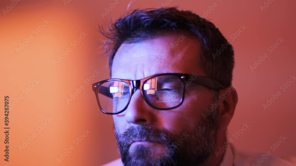 Poster portrait of serious man reading business report, article or document on computer screen. reflection 
