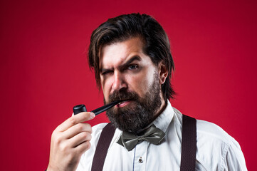 elegant brutal man smokes a pipe wearing formal bow tie, male style