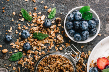 Granola with blueberry on dark metal background.