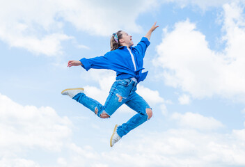 Fototapeta na wymiar teen girl wearing casual fashion clothes jumping high on sky background, energy