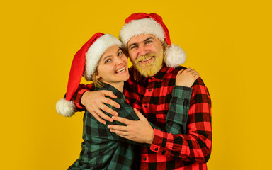 Santa team. Loving couple yellow background. Christmas magical time. We love christmas. Couple in love enjoy christmas holiday celebration. Family wear santa hats. Entertainment ideas for adults