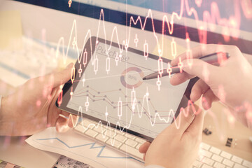 Double exposure of man's hands holding and using a phone and financial chart drawing. Market analysis concept.