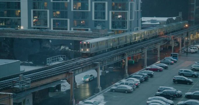 A Chicago Subway Train drives by in the snow in slow-motion (60fps). Wheels spark on tracks.
