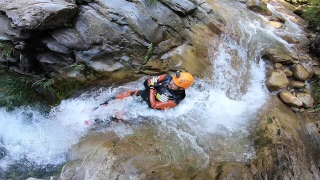 Man going down a slide in the Peira canyon, a spectacular canyon located in the French Alps.