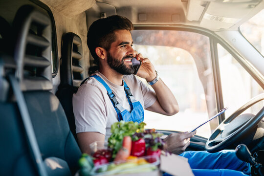 Young And Handsome Hispanic Male Working In Daily Home Delivery Service. He Is Positive And Smiled.