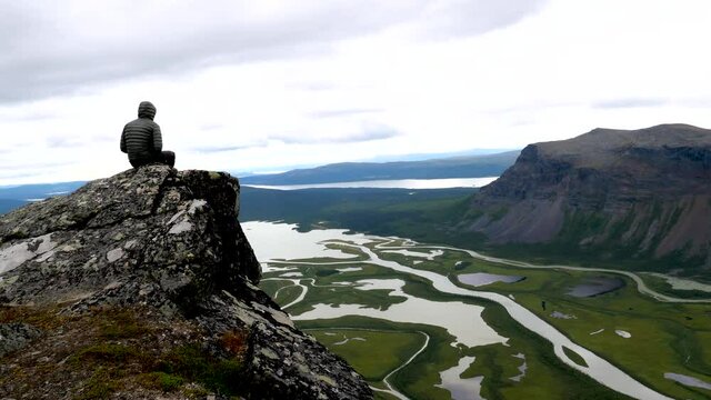 sitting on a cliff over a beautiful view in sarek, lappland sweden