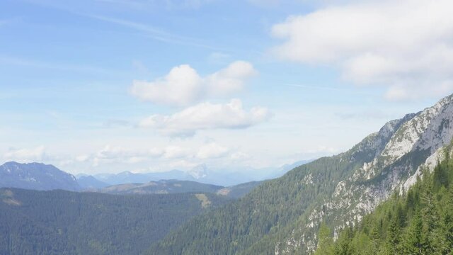 Distant mountain peaks. Rocks and forest of Alpine Peca. Aerial view