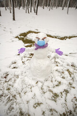 snowman in a medical mask and gloves