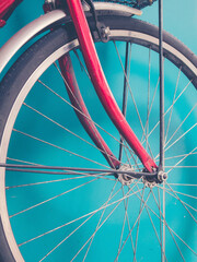 Wheel of a bicycle againt blue wall. Toned image.