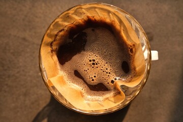 Drip coffee, drip brewing. Ground coffee beans are brewed with hot water contained in a paper filter.