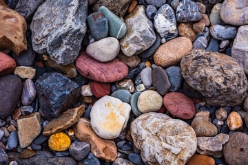 Background wallpaper of colorful stones left bySpiti river near its river bed in Spiti valley of Himachal Pradesh, India. Different rocks colors  are the result of the minerals that make up the rocks.