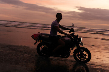 Fototapeta na wymiar Surfer rides on motorbike with surfboard at sunset ocean beach. Bali island, Indonesia