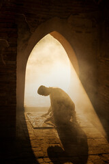 Blur  Silhouette religious of muslim male praying in old mosque with lighting and smoke background