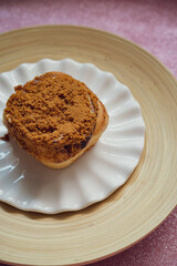 Cinnamon rolls with Lotus BIscoff crumbs topping on a white and bamboo plate.