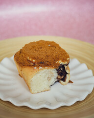 Cinnamon rolls with Lotus BIscoff crumbs topping on a white and bamboo plate.