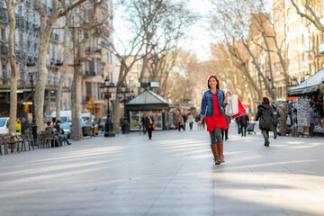 Outdoor shopping street Asian woman walking outside with shopping bags on La Rambla, Barcelona. Shopper enjoying sale. Tourist destination in Catalonia, Spain travel. - obrazy, fototapety, plakaty