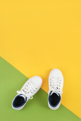 White sports shoes, sneakers with shoelaces on a green and yellow background. Sport lifestyle...