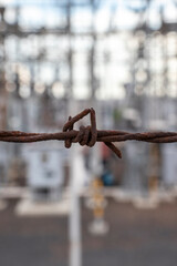 rusty barbed wire from a security fence of an electrical power transformer station