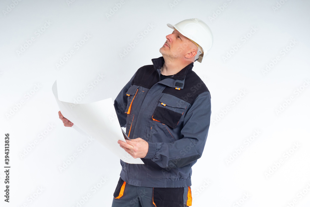 Poster engineer building on a white background. engineer building holds a sheet of paper in his hands. man 