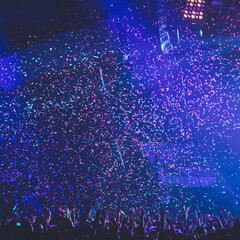 A crowded concert hall with scene stage lights, rock show performance, with people silhouette,...