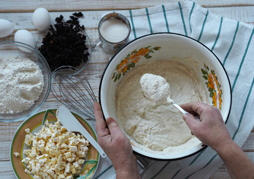 Kitchen table with ingredients for making semolina pie.Hands of an elderly woman kneading dough.Food pastry background.