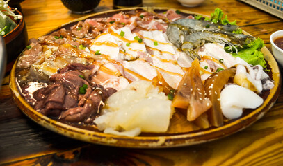 Fresh beef pork bacon squid and 
shrimp and vegetable on wood plate .Meet and vegetable shabu set.
