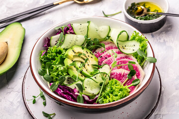 Salad from radish, avocado, microgreen, cabbage, cucumber and lettuce leaves. Healthy food. Vegetarian buddha bowl, Top view. Flat lay