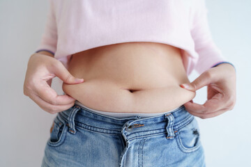 Women body fat belly. Obese woman hand holding excessive belly fat. diet lifestyle concept to...