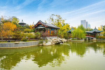 Fototapeta na wymiar In autumn, ancient buildings and arch bridges are in Yingze Park, Taiyuan, Shanxi Province, China