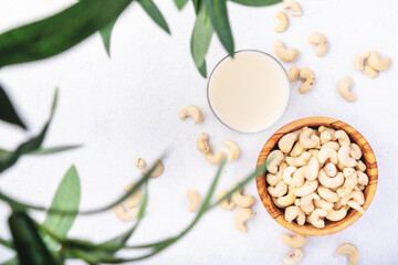 Fototapeta na wymiar Vegan Cashew nut milk on white background. Non dairy alternative vegan milk. Healthy vegetarian food and drink. Copy space, top view