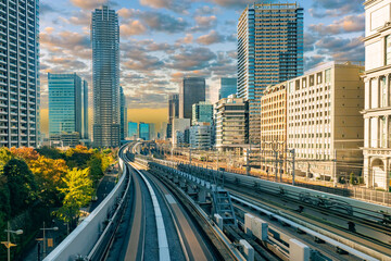 Fototapeta na wymiar Transport system of Japan. Railway and automobile tracks in the Japanese city. Transport of the Japanese capital. Road network on the background of office buildings. Travel to Japan.