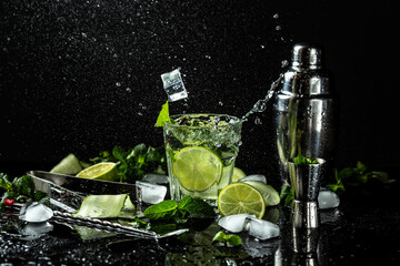 Refreshing detox water with fresh cucumber and slices of lime, fresh drink with liquid splash, freeze motion in jar glass on dark background, Healthy cucumber cocktail