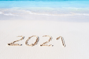 Year 2021 Written At The Sandy tropical Beach with coming sea waves