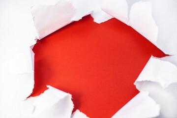 In the center is a torn white sheet with ragged edges inside which is a red background with space...