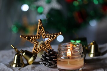 Fototapeta na wymiar Lit, scented mason jar candle/Christmas decoration/fairy light/Christmas celebration