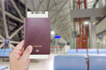 Man's hand holding international passport while wait at front the counter for check-in inside the Kansai International Airport (KIX) is one of Japan most important commercial airports.
