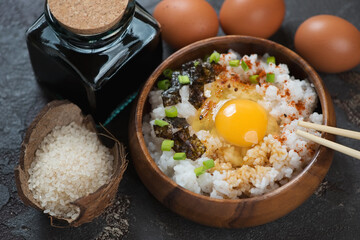 Wooden bowl with japanese tamago kake gohan or warm rice with a raw egg, studio shot