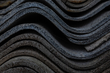 The texture of long layered waves, concrete slate roofing, solid tiles, aged, battered and cracked. Abstract gray retro background.