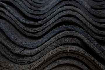 The texture of long layered waves, concrete slate roofing, solid tiles, aged, battered and cracked. Abstract gray retro background.