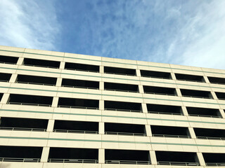 View of typical multi level parking garage facade and exterior under blue sky